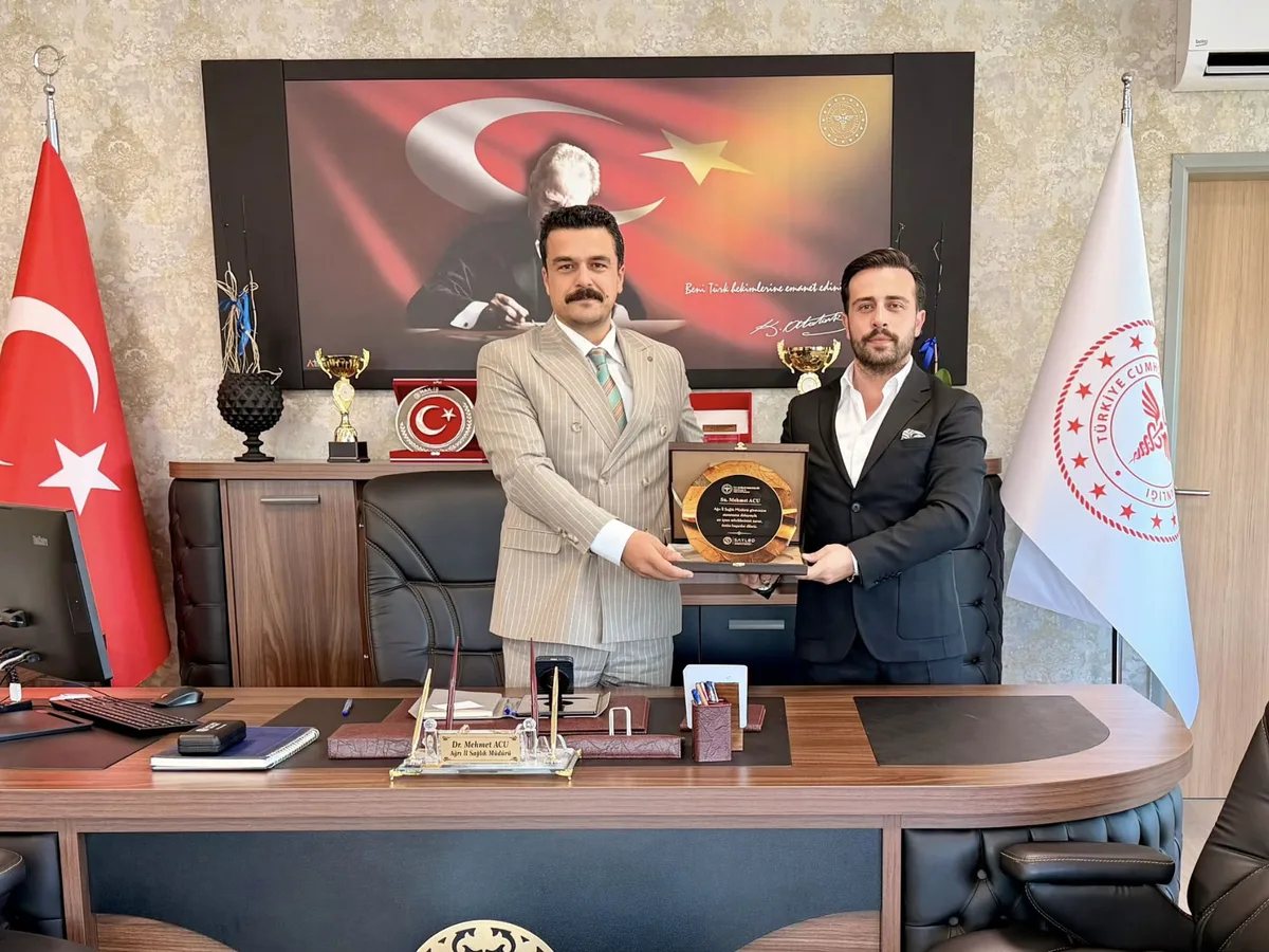 SAYLOD Yönetim Kurulu Başkanı Mesut Güler, Ağrı İl Sağlık Müdürü Dr. Mehmet Acu'ya makamında plaket takdim ederken.